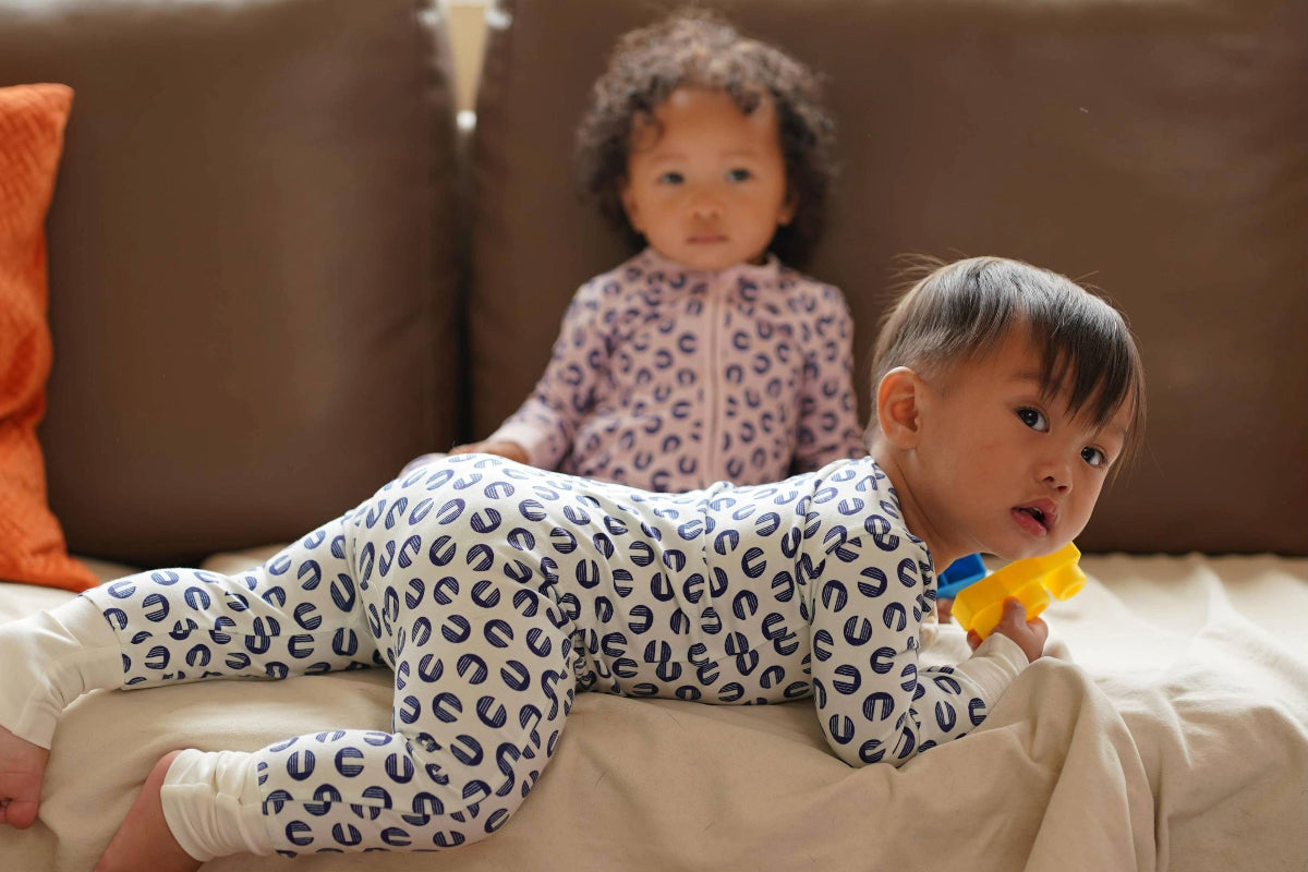 BABIES ON A COUCH WEARING ORGANIC COTTON KENDIKDIS ONESIE/ROMPER