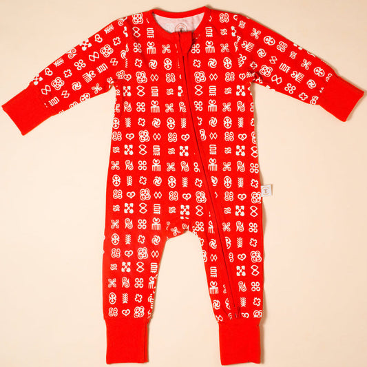Red onesie with white pattern on a beige background