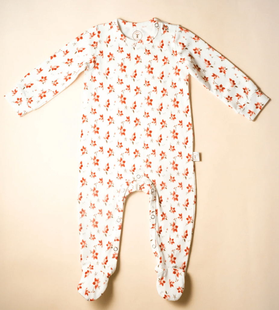 Floral-patterned baby onesie on a beige background