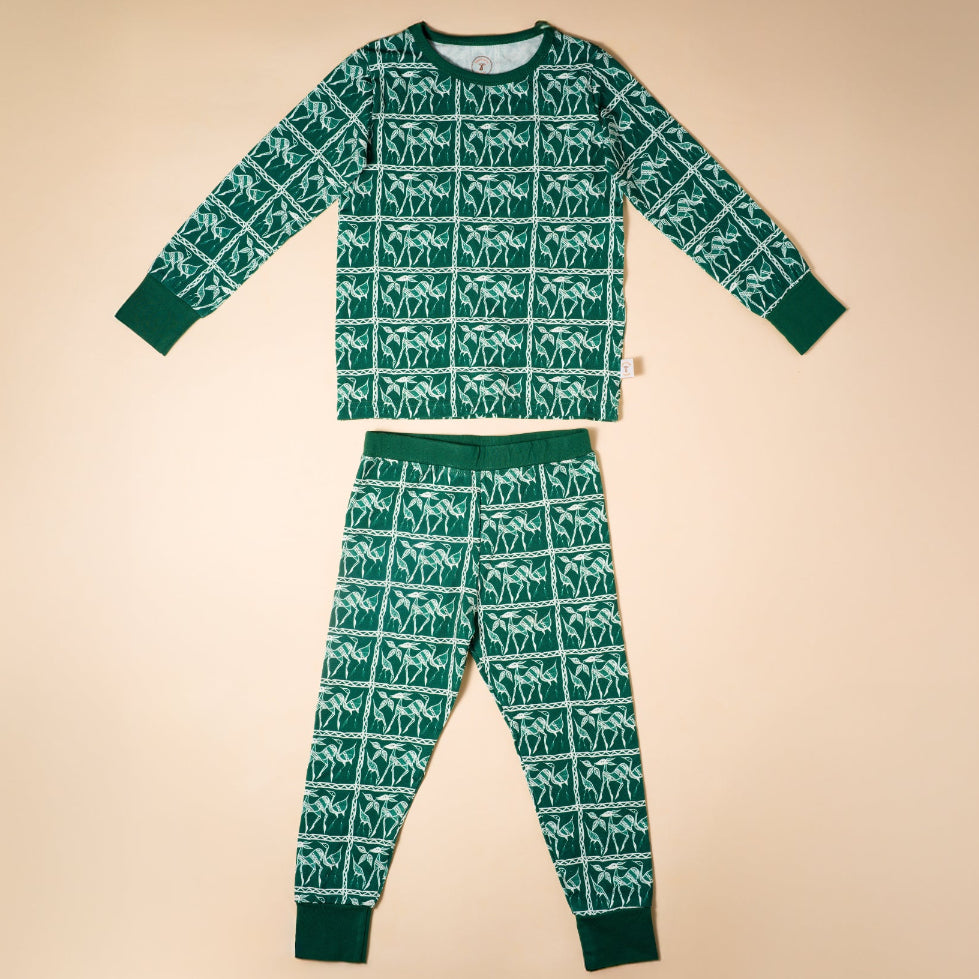 Green children's pajama set with white pattern on a beige background