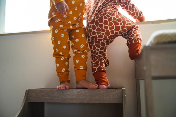 Two toddlers in KendiKids cowrie and giraffe print joggers