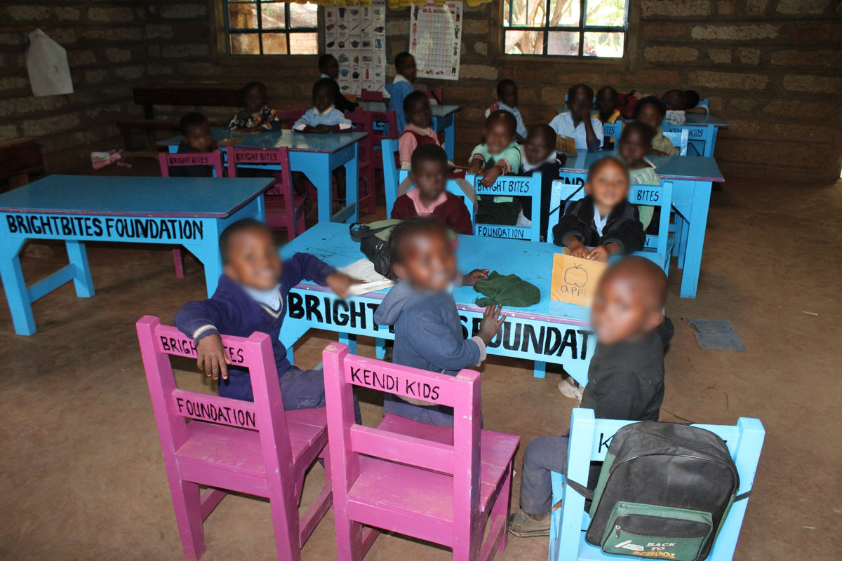 Children seated at blue desks and pink chairs made by KendiKids for the Good Shepherd dining hall in Meru, Kenya