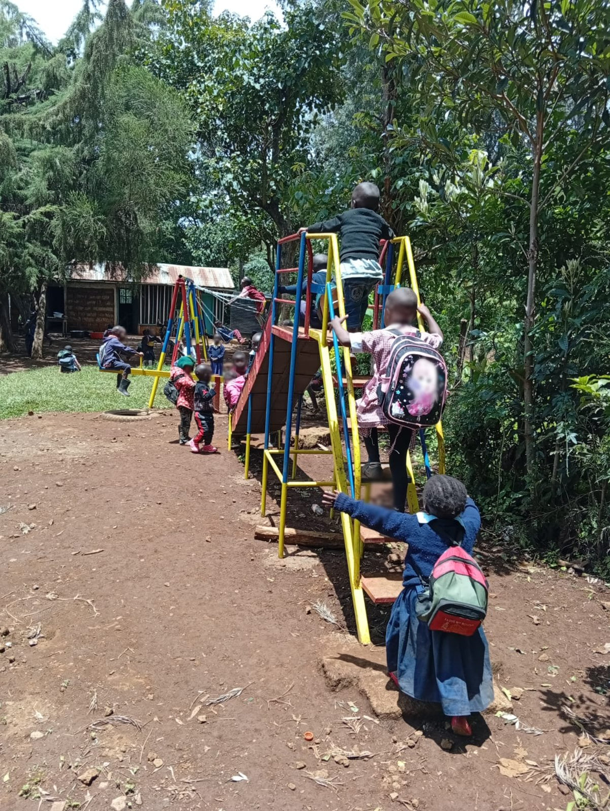 Children climbing the slide and frame of the playground KendiKids built at Good Shepherd, Meru