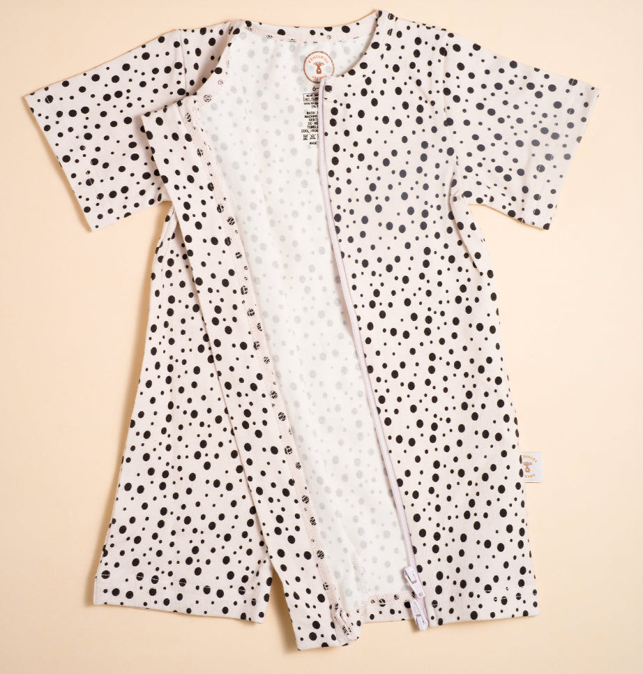 Polka dot baby romper on a beige background