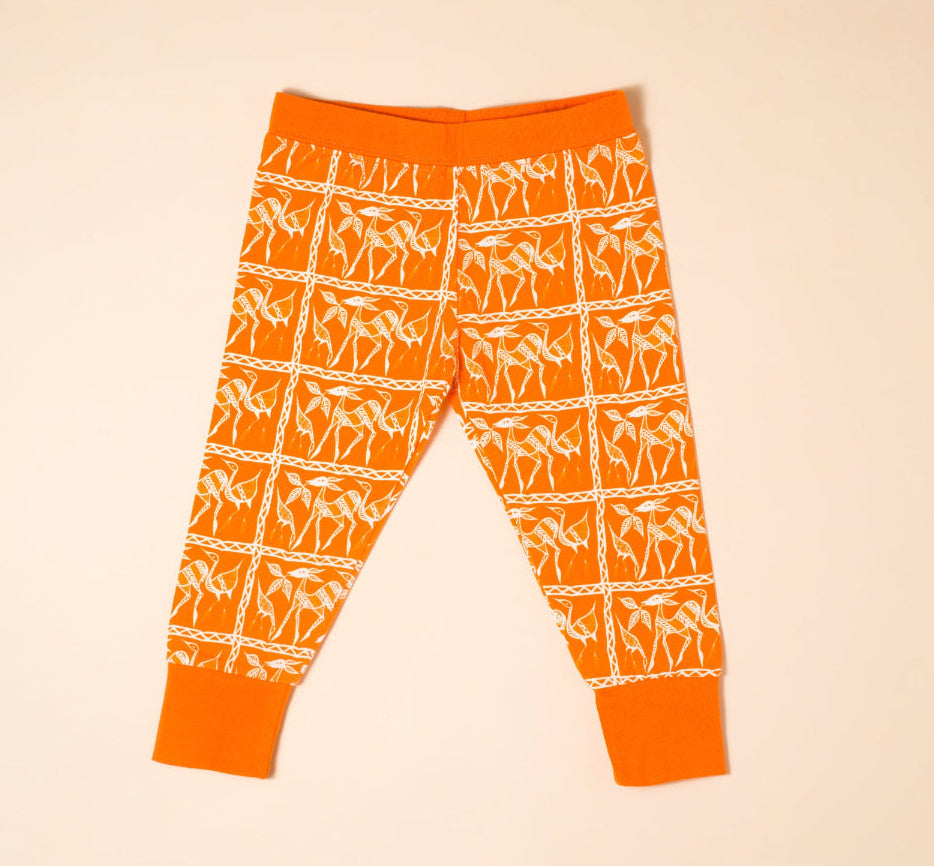 Orange leggings with white pattern on a beige background