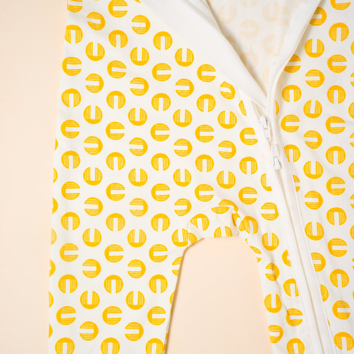 White romper with yellow geometric pattern on a beige background